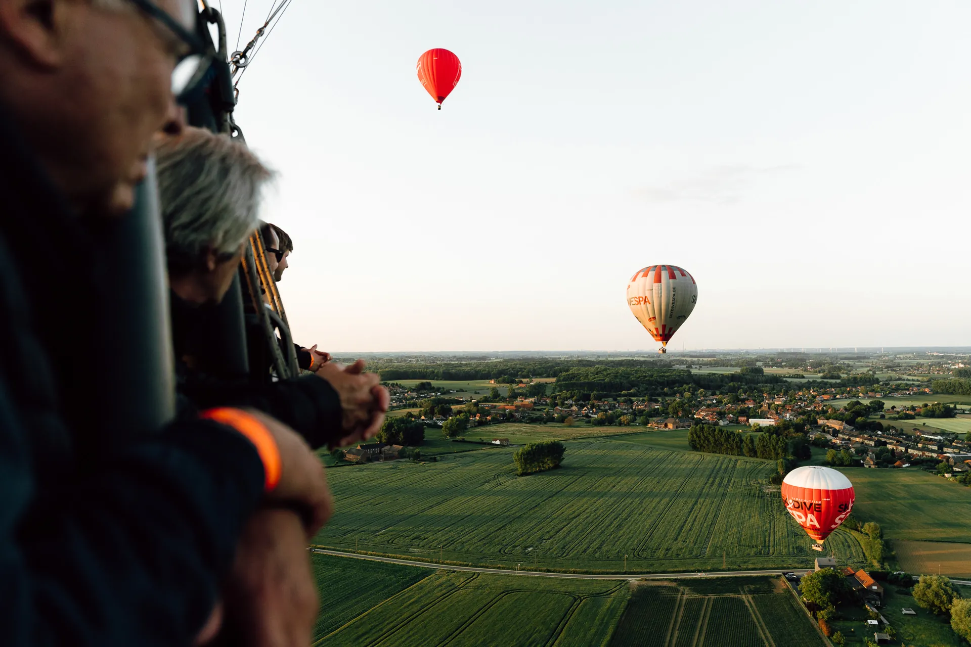 Hot-air balloons over the countryside, seen from the basket, during the AXA team building