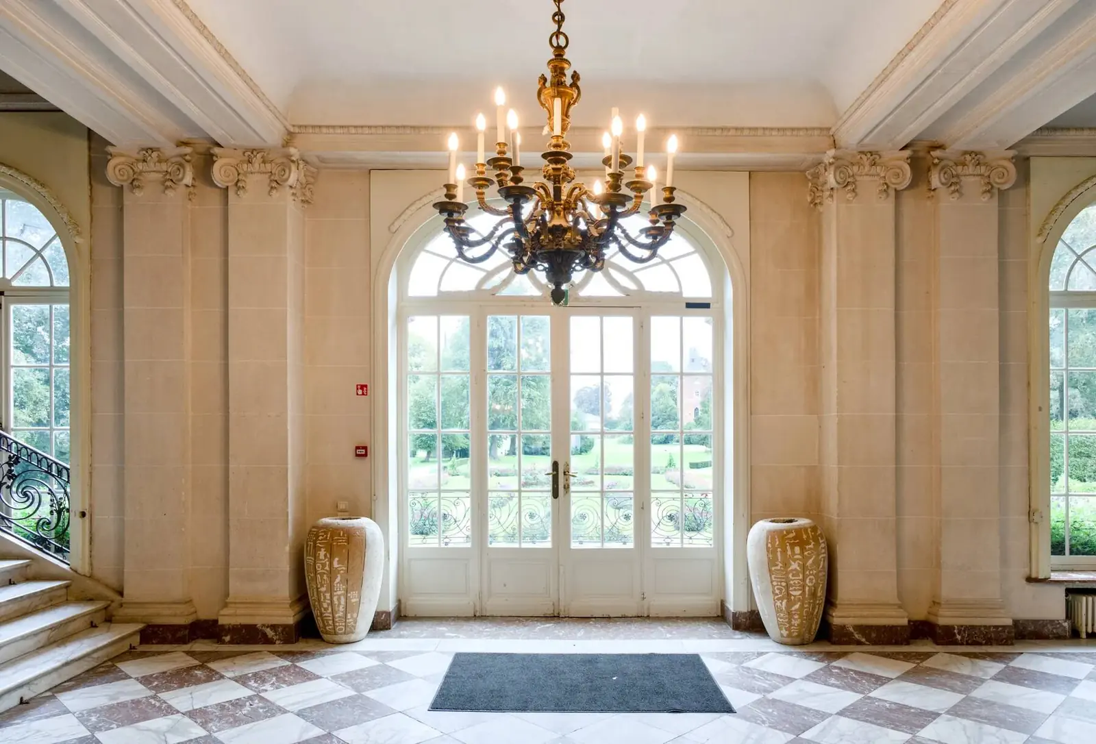 Tiled entrance hall with chandelier, opening onto the garden