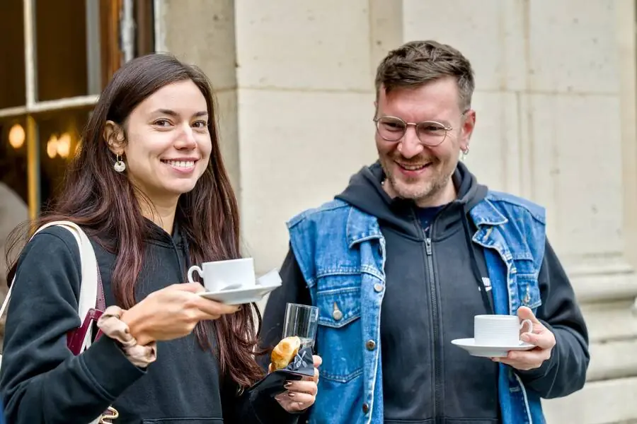 Two smiling participants, coffee in hand