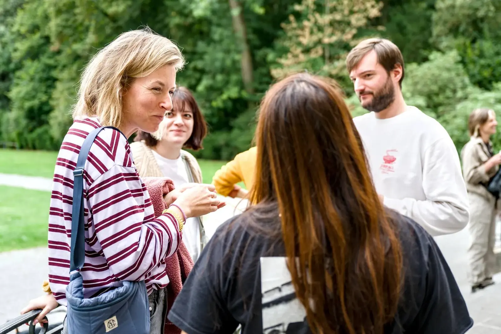 Colleagues chatting in the park, coffee in hand