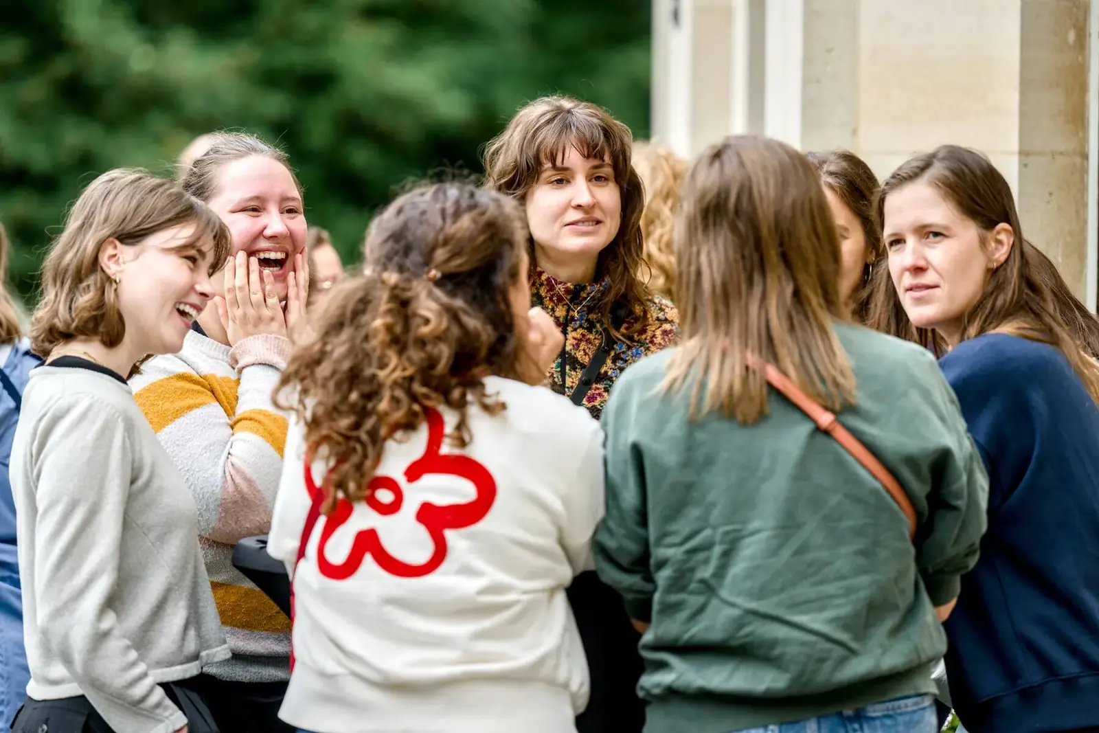 A group of colleagues bursting with laughter around a high table