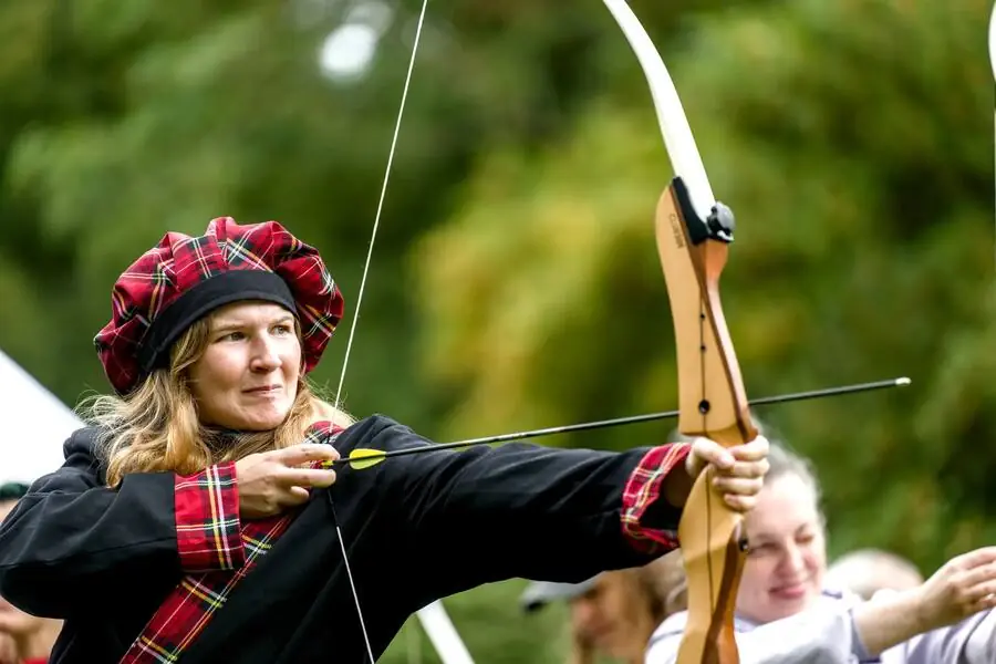 A participant draws a longbow