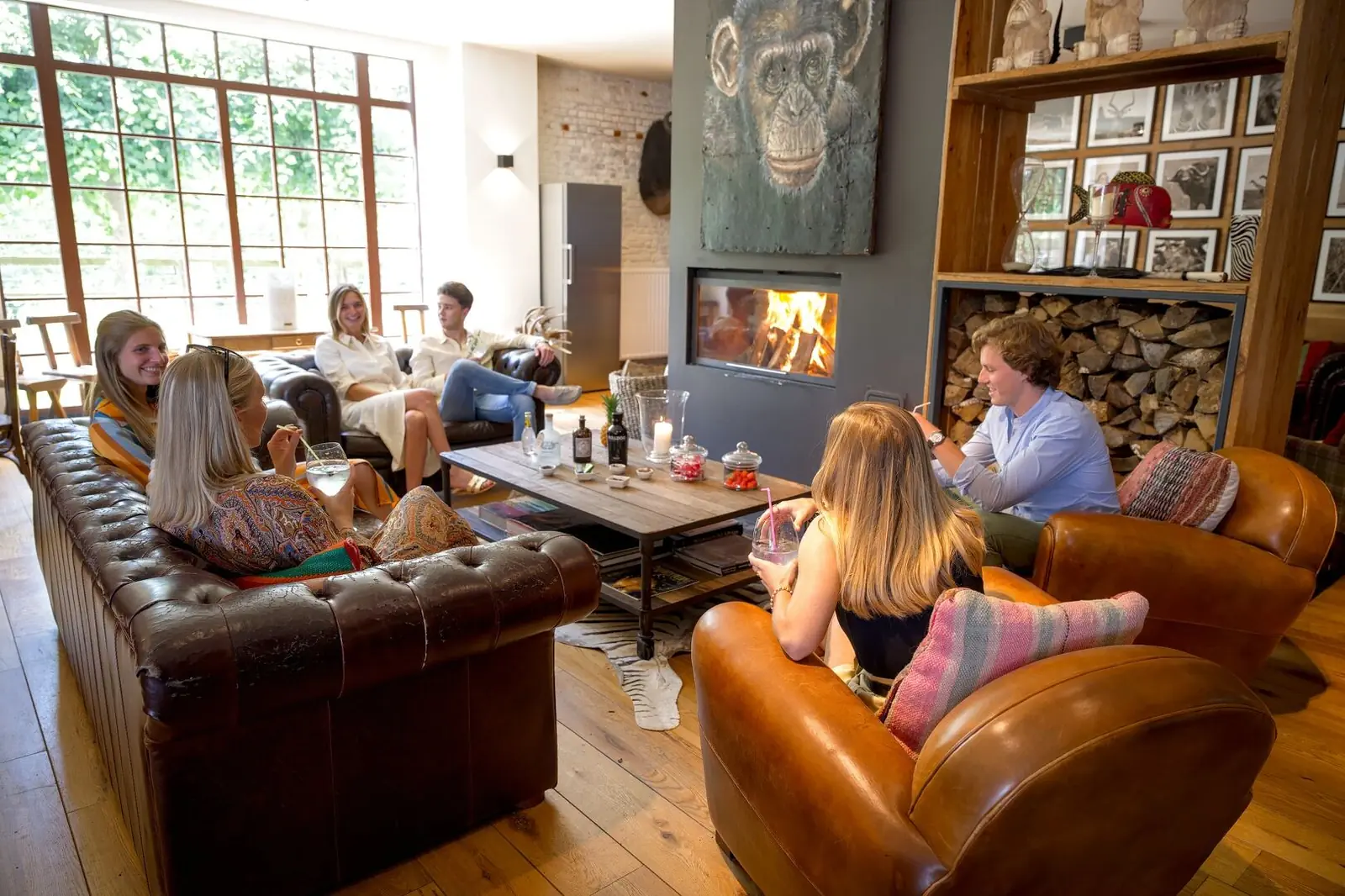 Colleagues enjoying drinks on the leather sofas by the fireside at the Green Cottage