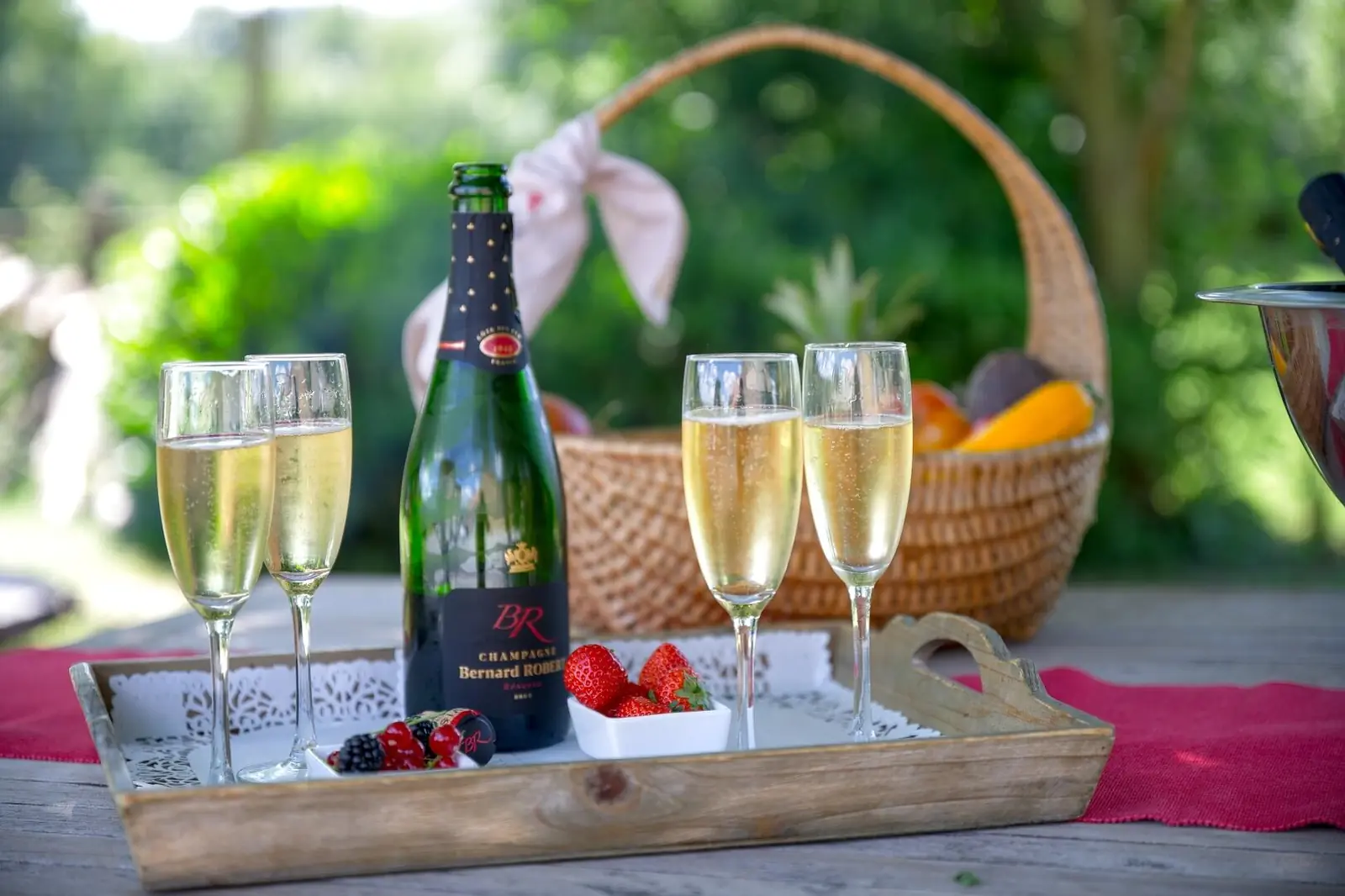 Champagne and coupes on a wooden table in the garden