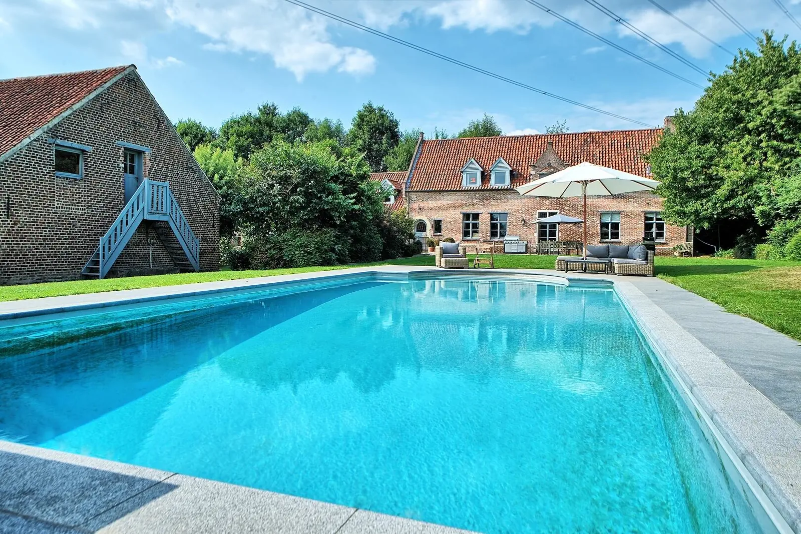 Outdoor pool in front of the Green Cottage's brick buildings