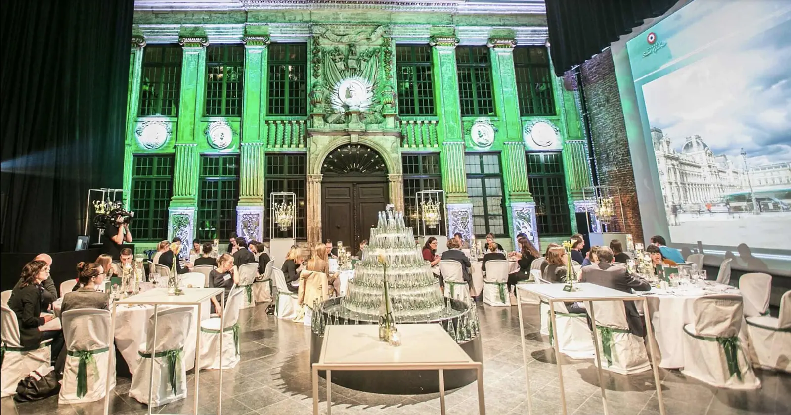 Gala dinner lit in green beneath the glass roof